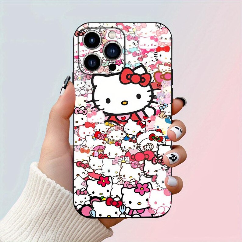 May include: A pink and white phone case with a Hello Kitty design. The case features a collage of Hello Kitty characters and images.