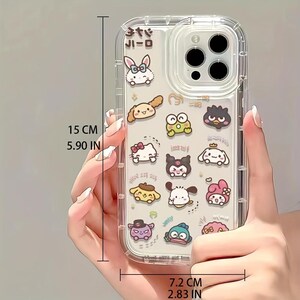 Puede incluir: Carcasa transparente para tel&eacute;fono con un dise&ntilde;o de varios personajes de dibujos animados, incluyendo Hello Kitty, My Melody y Tuxedo Sam. La carcasa mide 15 cm de alto y 7,2 cm de ancho. El texto "サンリオ" est&aacute; impreso en la carcasa.