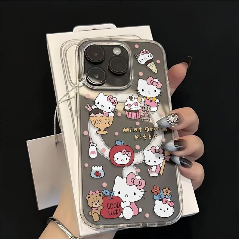 May include: Transparent phone case with a grey background, decorated with Hello Kitty and food illustrations. The case shows ice cream, cupcakes, and apples. Text on the case reads "mint green kitty" and "GOOD LUCK".