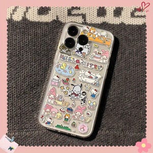 May include: Clear phone case decorated with colorful cartoon character stickers. The stickers feature various characters and scenes, including Hello Kitty, My Melody, and other Sanrio characters. The case has a clear background and a protective design.