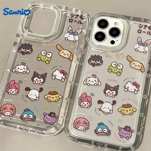 Puede incluir: Dos fundas transparentes para tel&eacute;fono con una variedad de personajes de Sanrio impresos en ellas. Los personajes incluyen Hello Kitty, My Melody, Cinnamoroll y Keroppi. Las fundas est&aacute;n etiquetadas con "Sanrio" y "ジ ャ ン ル".