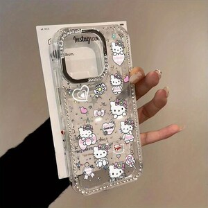 May include: Clear phone case with Hello Kitty graphics, pink hearts, bows, and flowers. The case has a rhinestone border and the word "Instagram" is visible. The case is designed for a phone.