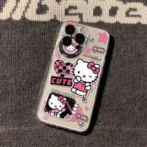 K&ouml;nnte beinhalten: Transparente Handyh&uuml;lle mit Hello Kitty-Grafiken. Die H&uuml;lle hat rosa Akzente, Sterne, Herzen und das Wort "CUTE". Die Hello Kitty-Figur wird in verschiedenen Posen mit einer rosa Schleife dargestellt.