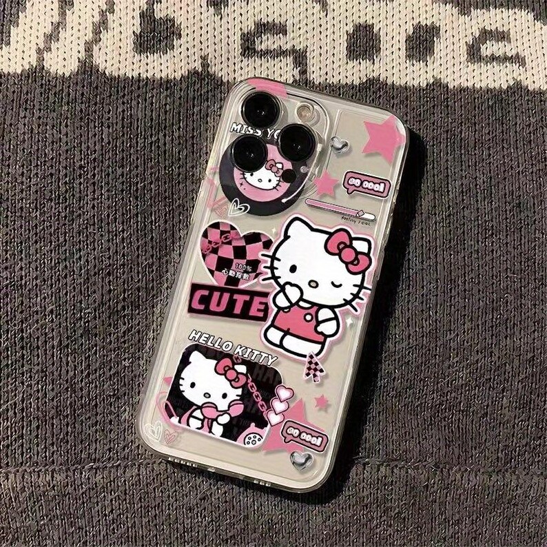 K&ouml;nnte beinhalten: Transparente Handyh&uuml;lle mit Hello Kitty-Grafiken. Die H&uuml;lle hat rosa Akzente, Sterne, Herzen und das Wort "CUTE". Die Hello Kitty-Figur wird in verschiedenen Posen mit einer rosa Schleife dargestellt.