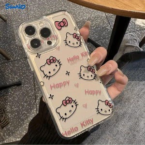May include: Clear phone case featuring a Hello Kitty design with pink bows and the words "Happy" and "Hello Kitty". The case has a transparent background and a protective design.