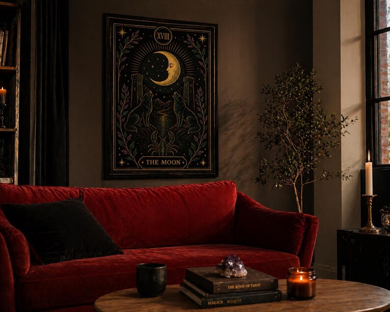 May include: A framed tarot card print featuring a crescent moon, two wolves, and the text "THE MOON." The artwork is in a dark color palette with gold and purple accents. The print hangs above a red velvet sofa with a black pillow.