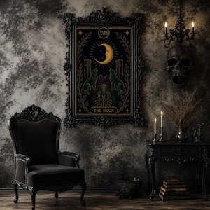 May include: A framed tarot card print featuring a crescent moon, two wolves, and the text "THE MOON." The artwork is in a black ornate frame, with a dark, gothic aesthetic. The room includes a black chair, side table, and skull decor.