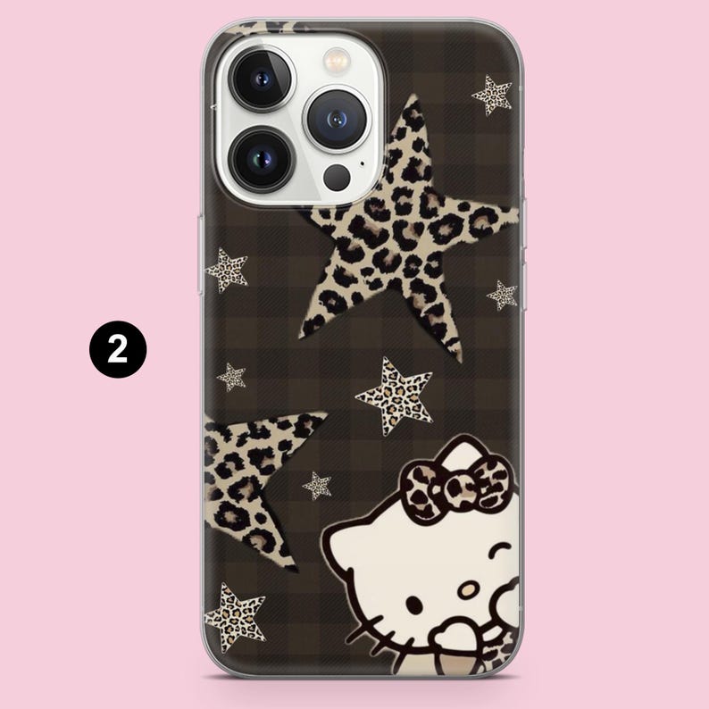 Puede incluir: Una funda transparente para smartphone con un patr&oacute;n de fondo de cuadros marr&oacute;n oscuro, varias estrellas con estampado de leopardo en beige y negro, y un personaje de gato blanco con un lazo a juego con estampado de leopardo, marcado con el n&uacute;mero 2.