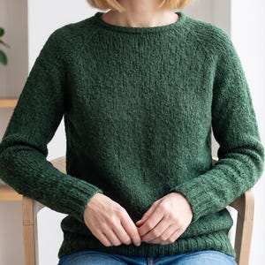 basic knitted raglan sweater beige minimal style
top down seamless knit sweater classic design
close up stockinette knit texture soft yarn detail
woman wearing simple knit sweater everyday outfit
handmade knitted pullover neutral cozy look