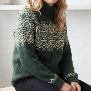 Pode incluir: Uma camisola de gola alta verde-floresta com um padrão geométrico creme no peito, ombros e punhos. A peça de malha tem mangas compridas, uma gola canelada e uma secção inferior verde sólida, proporcionando cobertura total do tronco.