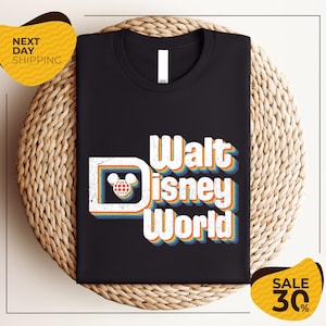 A black t-shirt with the text "Walt Disney World" printed on it, along with a Mickey Mouse logo. The t-shirt is displayed on a woven basket, and there are yellow price tags indicating a sale of 30% off.