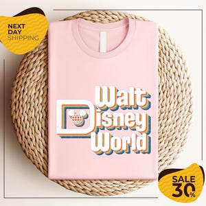 A pink t-shirt with the text "Walt Disney World" printed on it, placed on a woven basket. There are two yellow sale signs in the image, one on the left and one on the right, indicating a 30% discount on the item.