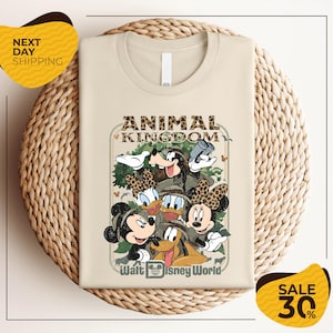 a t-shirt with a Disney-themed graphic design, including Mickey Mouse, Minnie Mouse, Donald Duck, and Goofy. The t-shirt is displayed on a woven basket, and there are two yellow sale signs indicating a 30% discount.