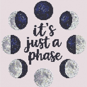 Könnte beinhalten: Ein Kreuzstichmuster auf hellrosa Stoff mit dem schwarzen Text 'it's just a phase' in der Mitte, umgeben von acht kreisförmigen Mondphasen-Illustrationen in Dunkelblau, Weiß und Grau, die in einer kreisförmigen Anordnung angeordnet sind.