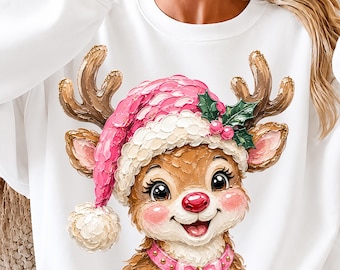 Könnte beinhalten: Ein weißes Langarm-Sweatshirt mit einer strukturierten, malerischen Grafik eines Rentiers, das eine rosa Weihnachtsmütze mit weißem Bommel, grünen Stechpalmenblättern und roten Beeren trägt. Das Rentier hat ein rosa Halsband mit einer goldenen Glocke.