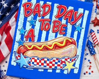 May include: A blue canvas print with the text "BAD DAY TO BE A HOT DOG" in red. The image features a hot dog with mustard in a checkered tray, surrounded by blue stars. Patriotic theme.