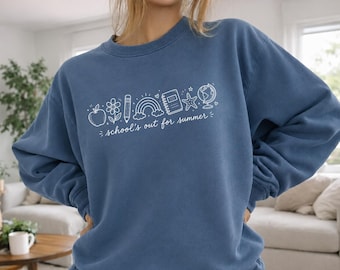 May include: A blue sweatshirt with white graphic of school supplies and the text "school's out for summer". The design includes an apple, flower, pencil, rainbow, notebook, star, and globe.