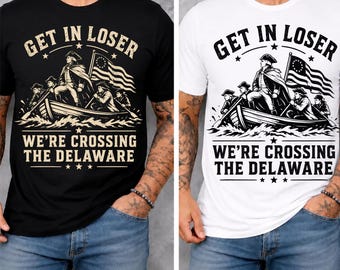 May include: Black and white t-shirts with the text "GET IN LOSER" above an illustration of a boat crossing a river, with the text "WE'RE CROSSING THE DELAWARE" below. The shirts are worn by a person.