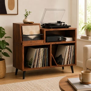 Op de afbeelding: Een mediaconsole van donker hout met een zwart draaiplateau op het bovenoppervlak en een schuin vak voor vinylplaten. De unit bevat een open plank voor audioapparatuur en twee onderste compartimenten die gevuld zijn met rijen vinylplaten.