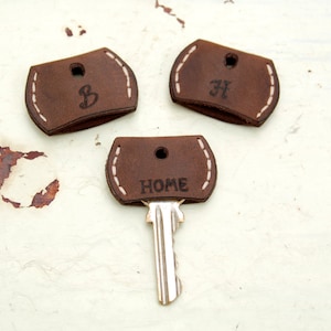 Juego personalizado de tres fundas de cuero para llaves, adorno para llave y tapa para llave