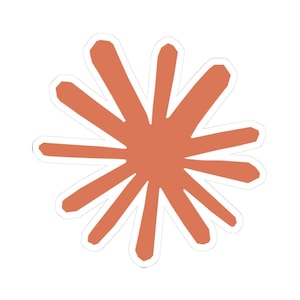 May include: A sticker featuring a stylized orange burst design with a white border. The burst has multiple pointed segments radiating outwards from a central point, creating a star-like shape. The sticker is on a white background.