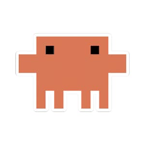 May include: A sticker featuring a pixelated orange creature with two black square eyes and four white legs. The sticker has a white border and a retro video game aesthetic.