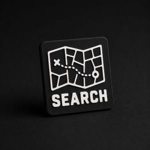 Peut inclure: Un écusson carré noir présentant un motif blanc en relief représentant une carte avec un chemin en pointillés menant à un marqueur de destination. Le mot SEARCH est imprimé en lettres capitales blanches sous le graphique de la carte.