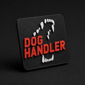 Może przedstawiać: Kwadratowa czarna naszywka z czerwonym napisem DOG HANDLER pogrubioną czcionką bezszeryfową. Wzór zawiera białe, spiczaste kły ułożone w kształt otwartej szczęki otaczającej tekst, tworząc kontrastujący emblemat graficzny o wyraźnym wyglądzie.