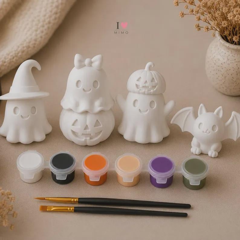 May include: A set of four white ceramic Halloween figurines including a ghost with a witch hat, a ghost on a pumpkin, a ghost with a pumpkin hat, and a bat. Includes a strip of six paint pots in various colours and two black paint brushes.