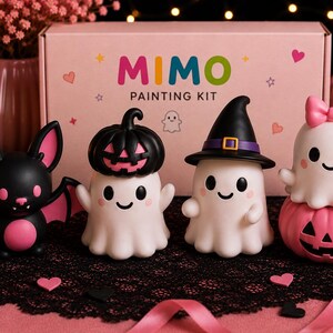 May include: A Mimo Painting Kit box featuring four small figurines: a black and pink bat, a white ghost with a black pumpkin hat, a white ghost wearing a black witch hat, and a white ghost with a pink bow sitting on a pink jack-o'-lantern.