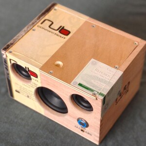 May include: A handmade wooden speaker crafted from a cigar box. The speaker features two black speakers, a blue power button, and the text "nub Connecticut". A label reading "Republic" is visible on the side.