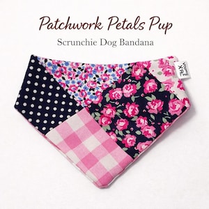 May include: A scrunchie dog bandana with a patchwork design. The bandana features navy blue polka dots, pink gingham, and floral patterns in pink, blue, and white. The text "Patchwork Petals Pup" and "Scrunchie Dog Bandana" are visible.
