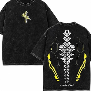 May include: Black t-shirt with a yellow and white graphic design. The front features a yellow abstract design, while the back displays a white and yellow skeletal design with the text "CYBERPUNK". The shirt has a washed, vintage look.