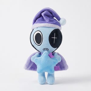 May include: A plush toy alien with a blue body, wearing a purple nightcap and cape. The alien has one large eye and a stitched cross on the other eye. It holds a blue star and has a small, worried expression.