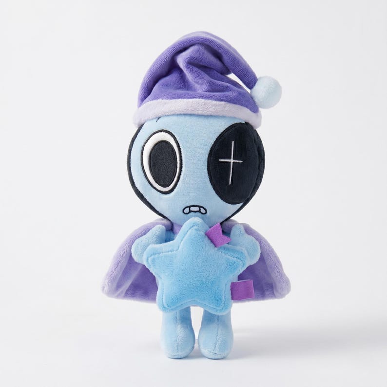 May include: A plush toy alien with a blue body, wearing a purple nightcap and cape. The alien has one large eye and a stitched cross on the other eye. It holds a blue star and has a small, worried expression.
