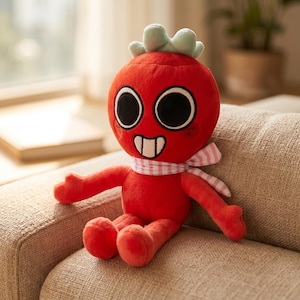 May include: A plush red character with large black eyes, a white-toothed grin, and a light pink and white checkered scarf. The character has small arms and legs and a green leafy top. It is sitting on a beige couch.