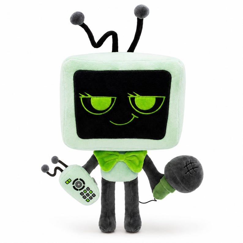 May include: A soft toy resembling a vintage television set, featuring a black screen and green trim. It has a green bow tie, a remote control, and a microphone. The toy's main colours are green, black, and grey.