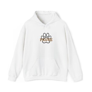 May include: White hooded sweatshirt with a front pocket and drawstring. The design features a black paw print with the word "PAUSE" in brown letters. A casual and comfortable apparel item.