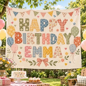 May include: A rectangular fabric birthday banner featuring the text HAPPY BIRTHDAY EMMA in large, multi-colored patterned letters. The design includes a bunting flag border, illustrated balloons, and a red and white gingham bow at the bottom.