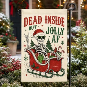 Könnte beinhalten: Eine rechteckige Gartenflagge mit einem Skelett, das eine Weihnachtsmütze und eine Sonnenbrille trägt und in einem roten Schlitten voller Geschenke sitzt. Der Text lautet DEAD INSIDE BUT JOLLY AF, ergänzt durch grüne Tannen und rote Sterne.