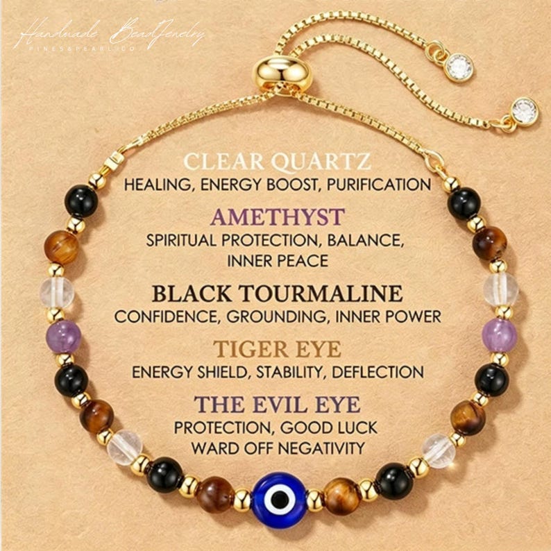 May include: A gold-tone adjustable bracelet featuring a central blue evil eye bead, interspersed with clear quartz, amethyst, black tourmaline, and tiger eye beads. The text lists the stones and their properties, including Clear Quartz, Amethyst, Black Tourmaline, Tiger Eye, and The Evil Eye.