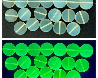 May include: Two rows of round, white glass beads, each with a line down the centre. The beads are shown in normal light and under a black light, where they glow green.