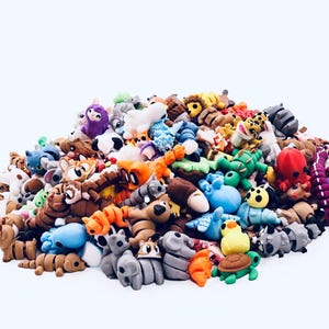 Puede incluir: Un montón de coloridas figuras de animales en miniatura. La colección incluye una variedad de criaturas, como elefantes, leones, tortugas y pulpos, en tonos azules, marrones, verdes y naranjas. Las figuras están hechas de un material blando.