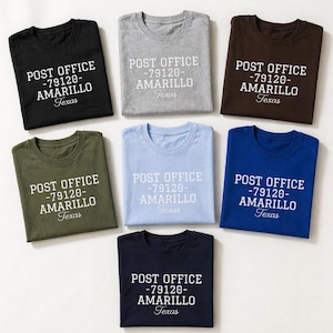 May include: Seven t-shirts in various colors, including black, gray, brown, olive green, light blue, dark blue, and navy. Each shirt features the text "POST OFFICE -79120- AMARILLO Texas" in white, centered on the front.