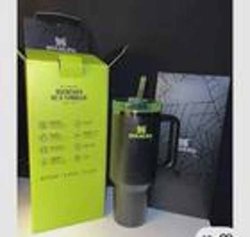 May include: A black Stanley tumbler with a handle and straw, shown with its packaging. The box is lime green with white text and icons. A black lid and a black box with a logo are also visible.