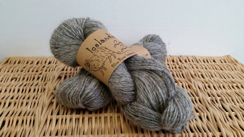 May include: Two skeins of gray Icelandic yarn with a brown label that reads "Icelandic Blue River Handspun".