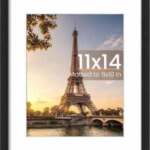 May include: Black framed print of the Eiffel Tower in Paris, France, at sunset. The print is matted to 8x10 inches and framed to 11x14 inches. The image features the iconic tower, a river, and a bridge.