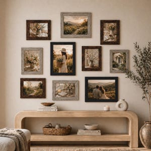 May include: A collection of framed art prints in various sizes and styles, arranged on a neutral-toned wall. The frames are in shades of brown, black, and gray, with images of landscapes, flowers, and people. A wooden console table with decor sits below the frames.