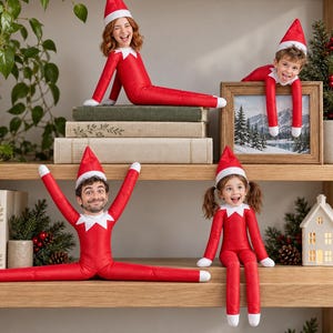 May include: Four plush elf dolls with custom photographic faces, each wearing a red suit with a white collar and a matching red pointed hat. The dolls are posed in various positions on wooden shelves alongside books and holiday decor.