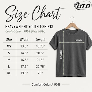 K&ouml;nnte beinhalten: Eine Gr&ouml;&szlig;entabelle f&uuml;r Comfort Colors 9018 T-Shirts f&uuml;r Jugendliche, mit einem dunkelgrauen T-Shirt auf einem Kleiderb&uuml;gel und Ma&szlig;pfeilen. Die Tabelle listet die Gr&ouml;&szlig;en XS bis XL mit den entsprechenden Ma&szlig;en in Zoll auf.